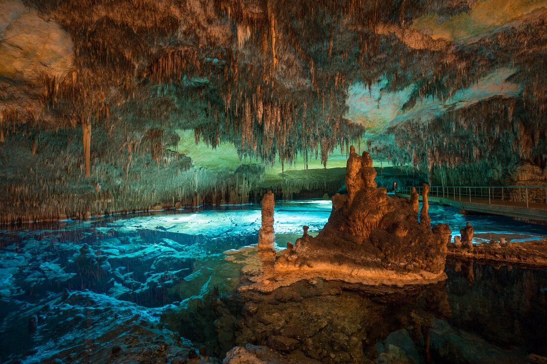 Höhle mit Stalaktiten und türkisblauem Wasser in Mallorca