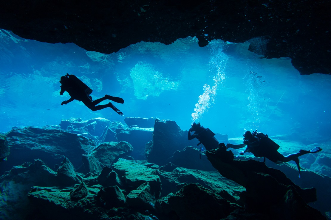 Zwei Taucher in einer Höhle unter Wasser