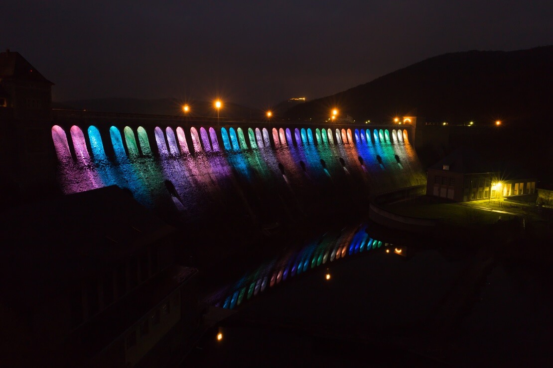 Speermauer am Edersee leuchtet in bunten Farben bei Dunkelheit