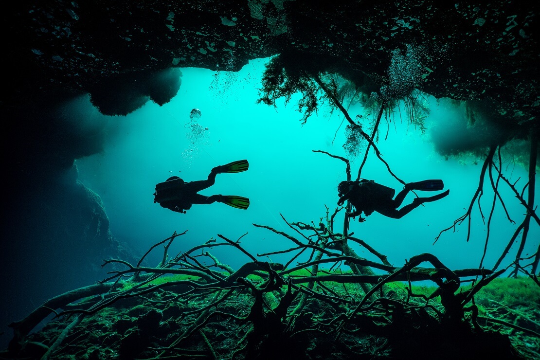 Zwei Taucher tauchen in einer Höhle