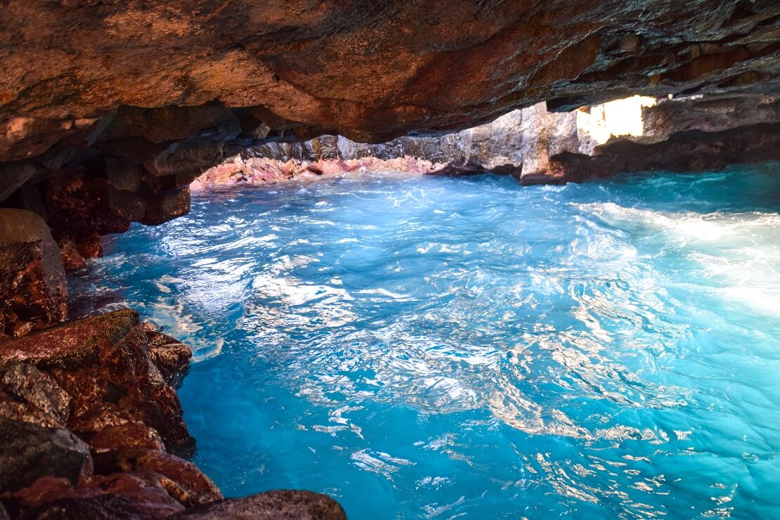 Felsige Höhle mit klarem und blauen Wasser