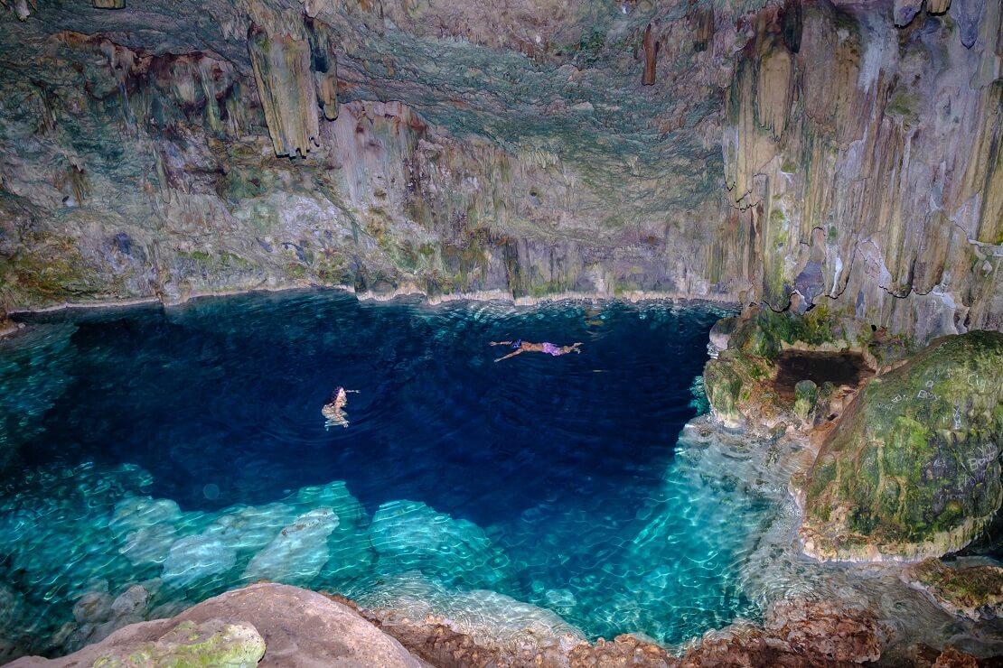 Taucher schwimmen in einer Höhle mit tief Blauen Wasser