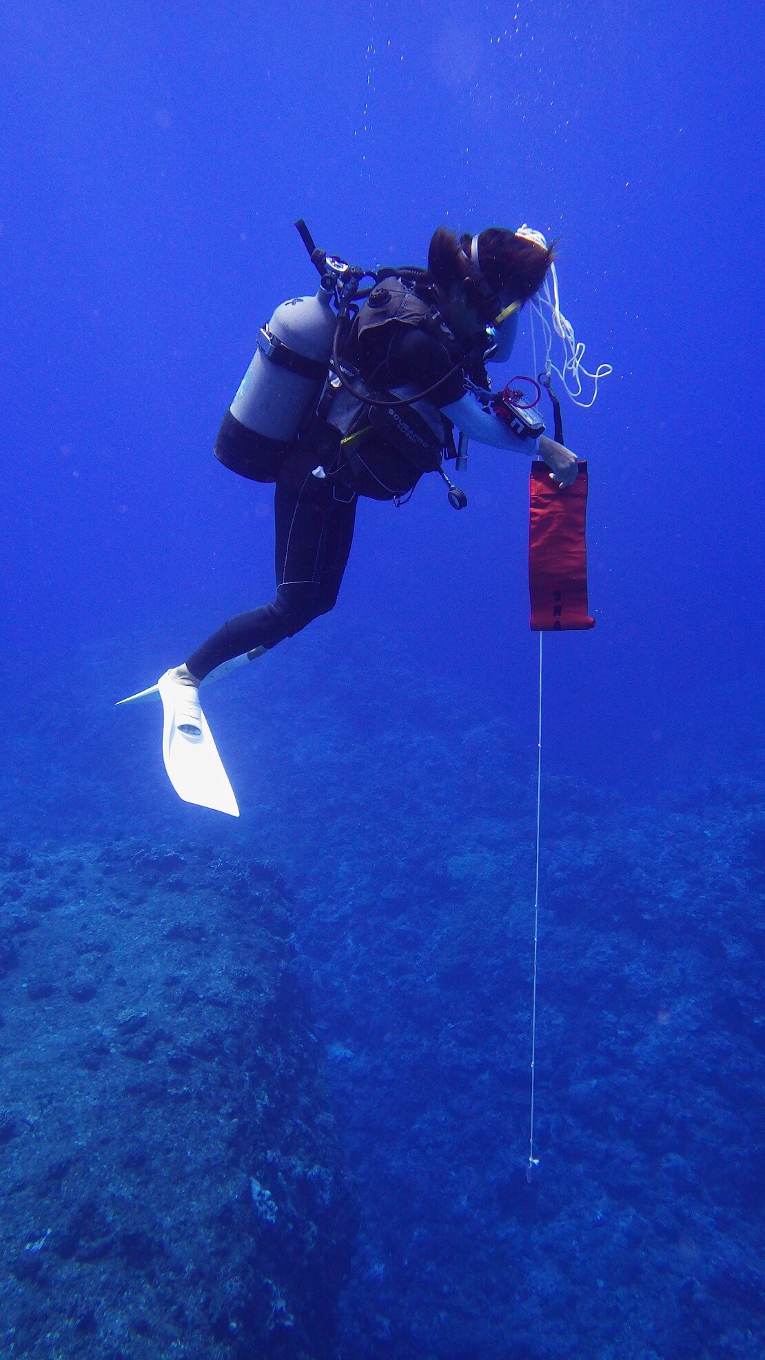 Taucher öffnet die Signalboje unter Wasser