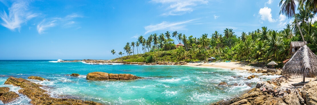 Weißer Sandstrand mit türkisblauen Meer