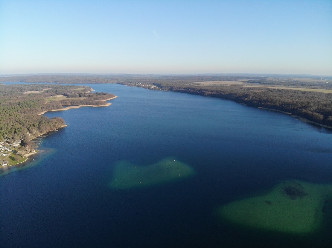 Tiefblauer See umgeben von Bäumen