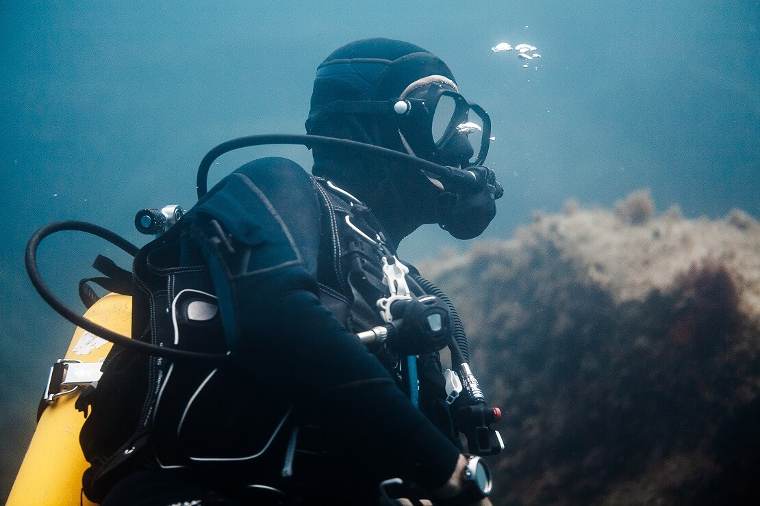 Taucher mit Atemregler im Mund unter Wasser