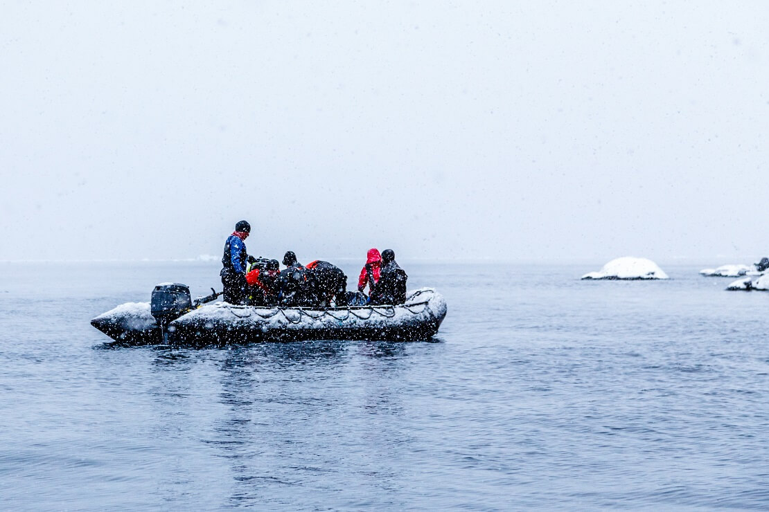 Menschen sitzen auf einem Schlauchboot in der Antarktis