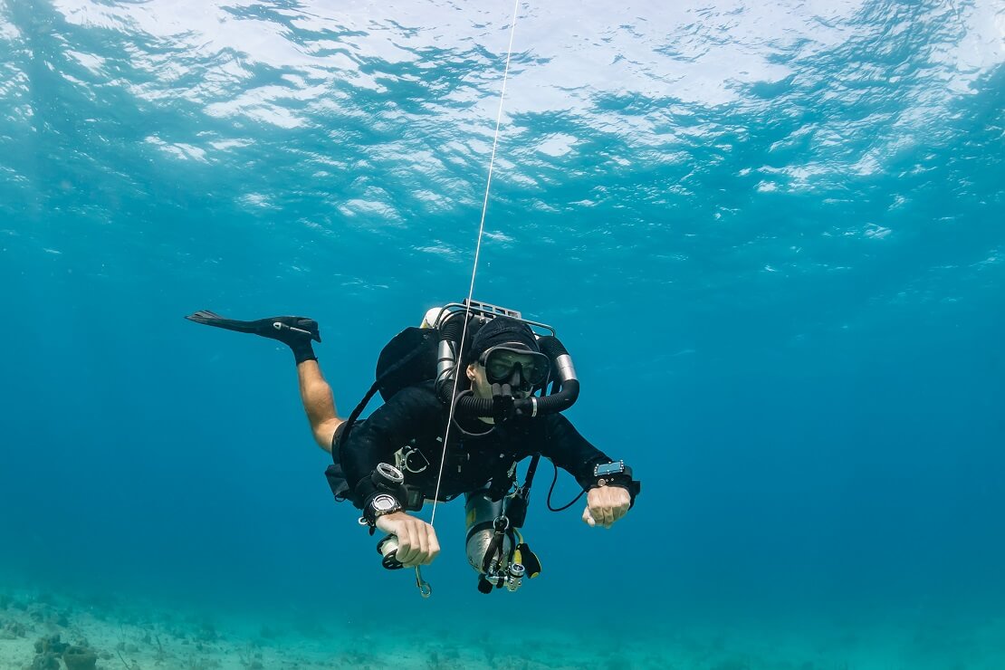 Taucher unter Wasser mit einer Schnur in der Hand