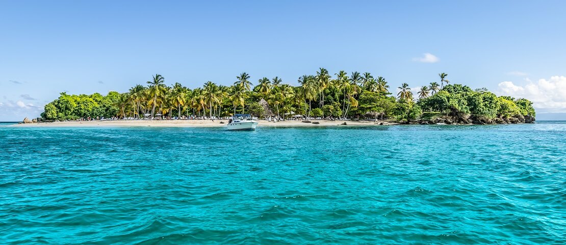 Türkisblaues Wasser umgibt eine Insel mit vielen Palmen