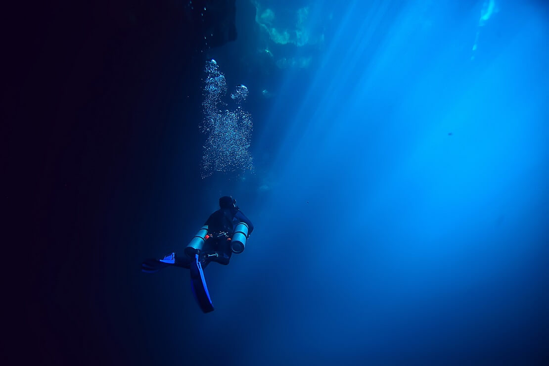 Taucher schwimmt aus den Tiefen auf