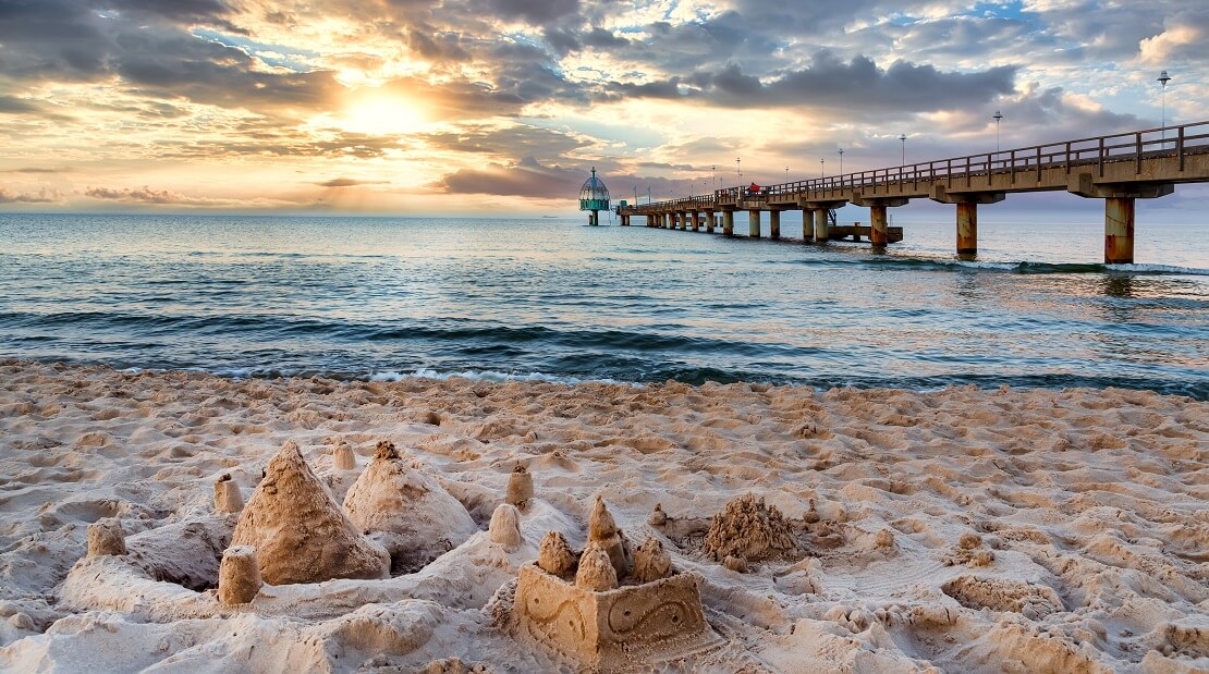 Strand an der Ostsee mit dem Meer und dem Sonnenuntergang im Hintergrund