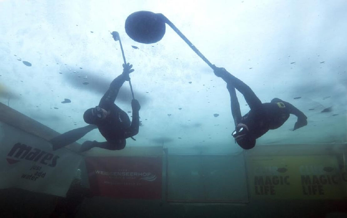 Zwei Spieler jagen den Puck im Unterwasser-Eishockey