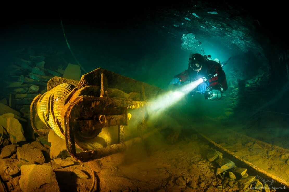 Ein Taucher erforscht Geräte im Bergwerk Nuttlar