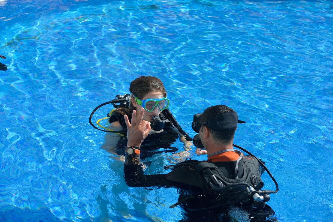 Tauchlehrer mit Schülerin im Schwimmbad