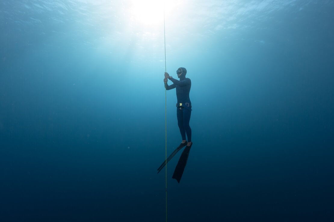 Apnoetaucher in tiefblauem Wasser